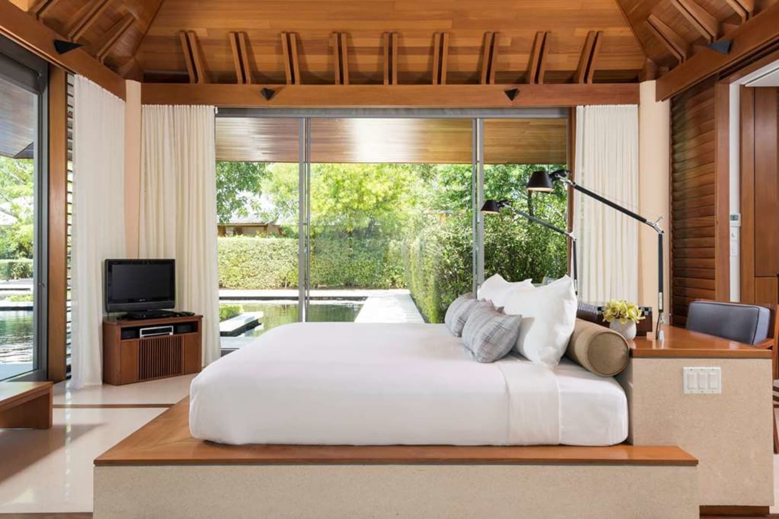 Bedroom facing the garden through glass walls