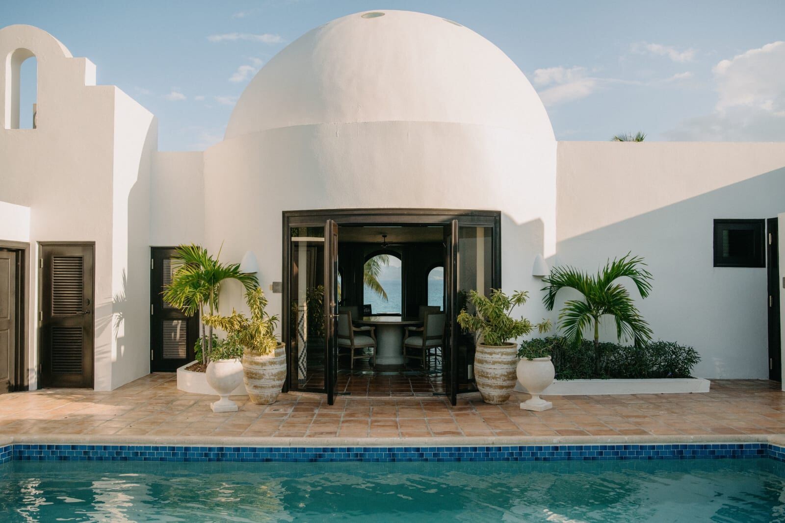 Whitewashed domed building beyond a pool