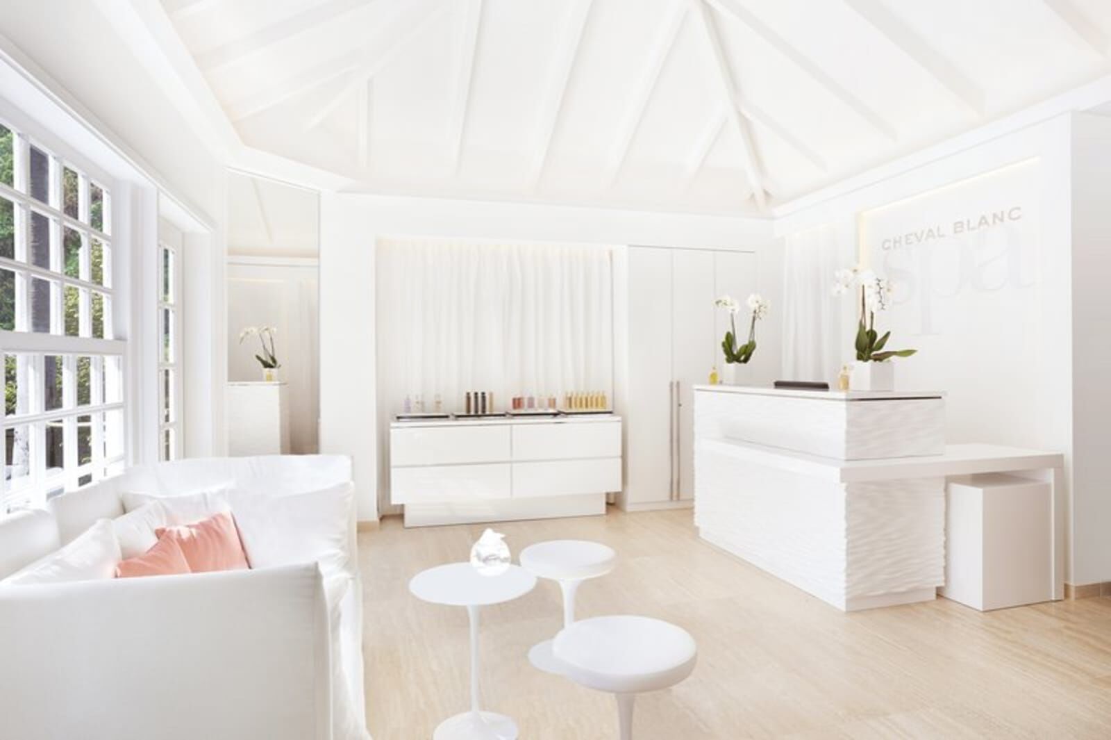 White reception room with a sofa and stools