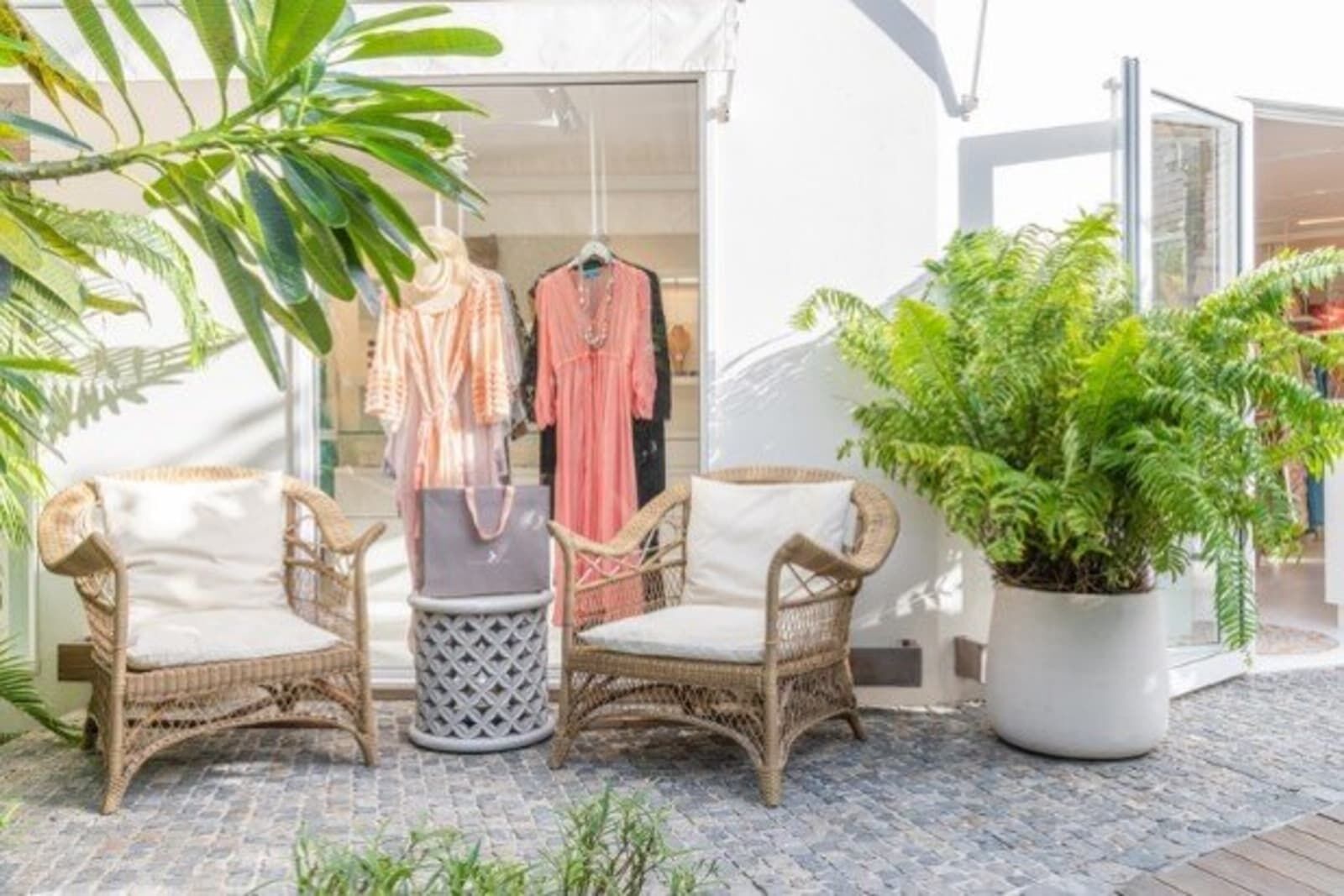 Boutique with wicker armchairs and dresses on display