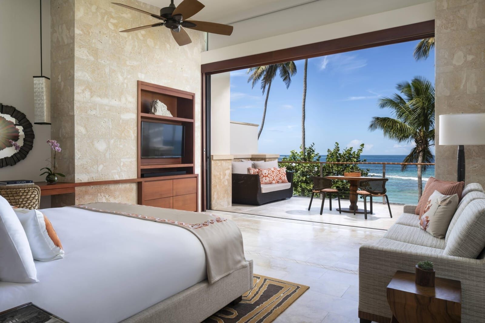 Bed facing an open terrace and the sea