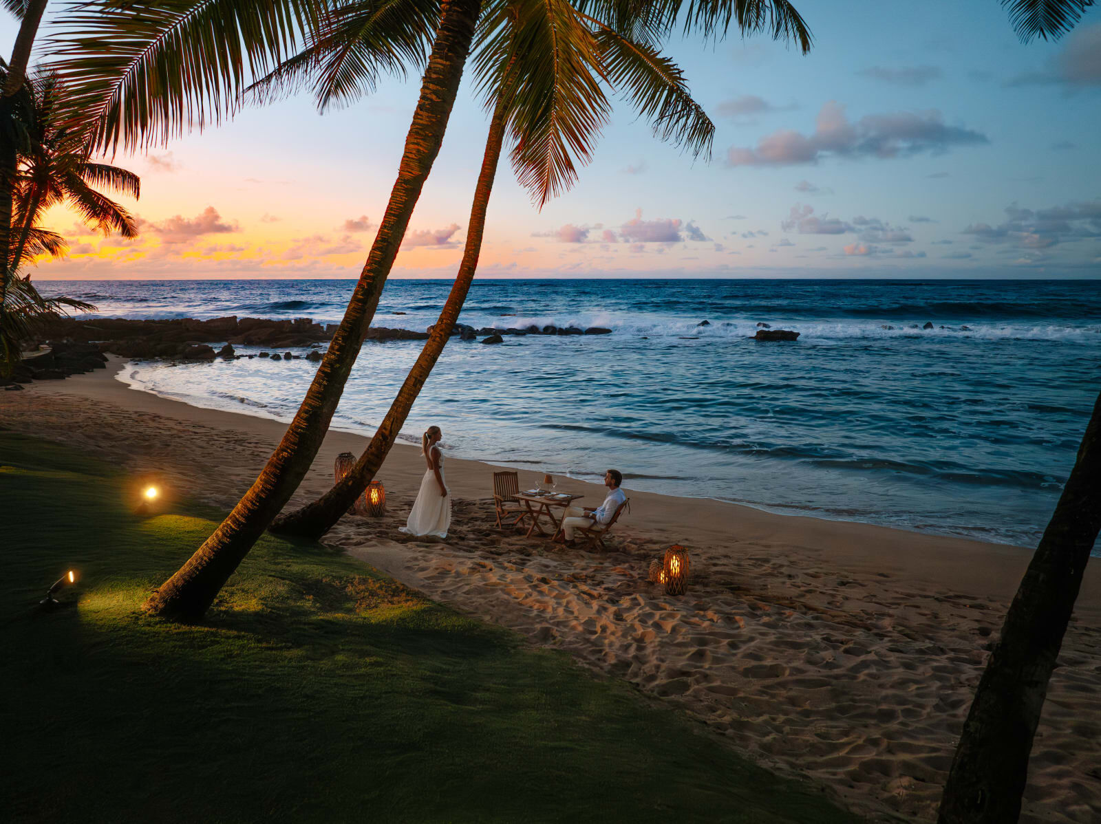 Dinner by lantern light on the beach at sunset