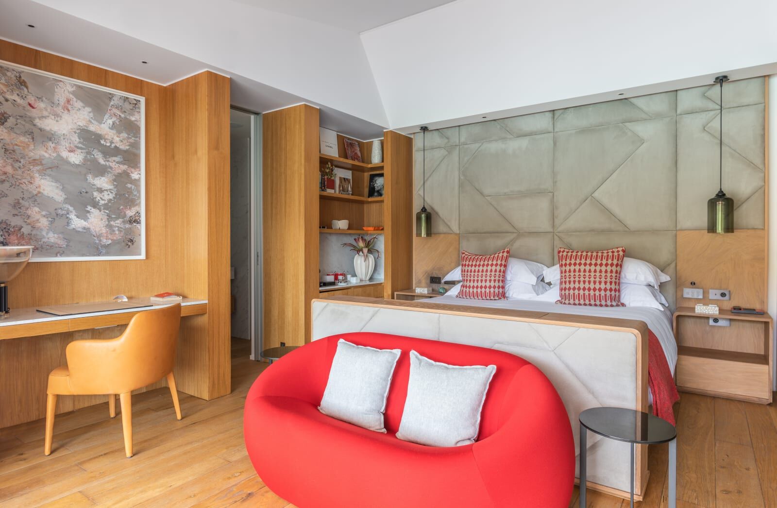 Bedroom with a red sofa and wood-panelled walls