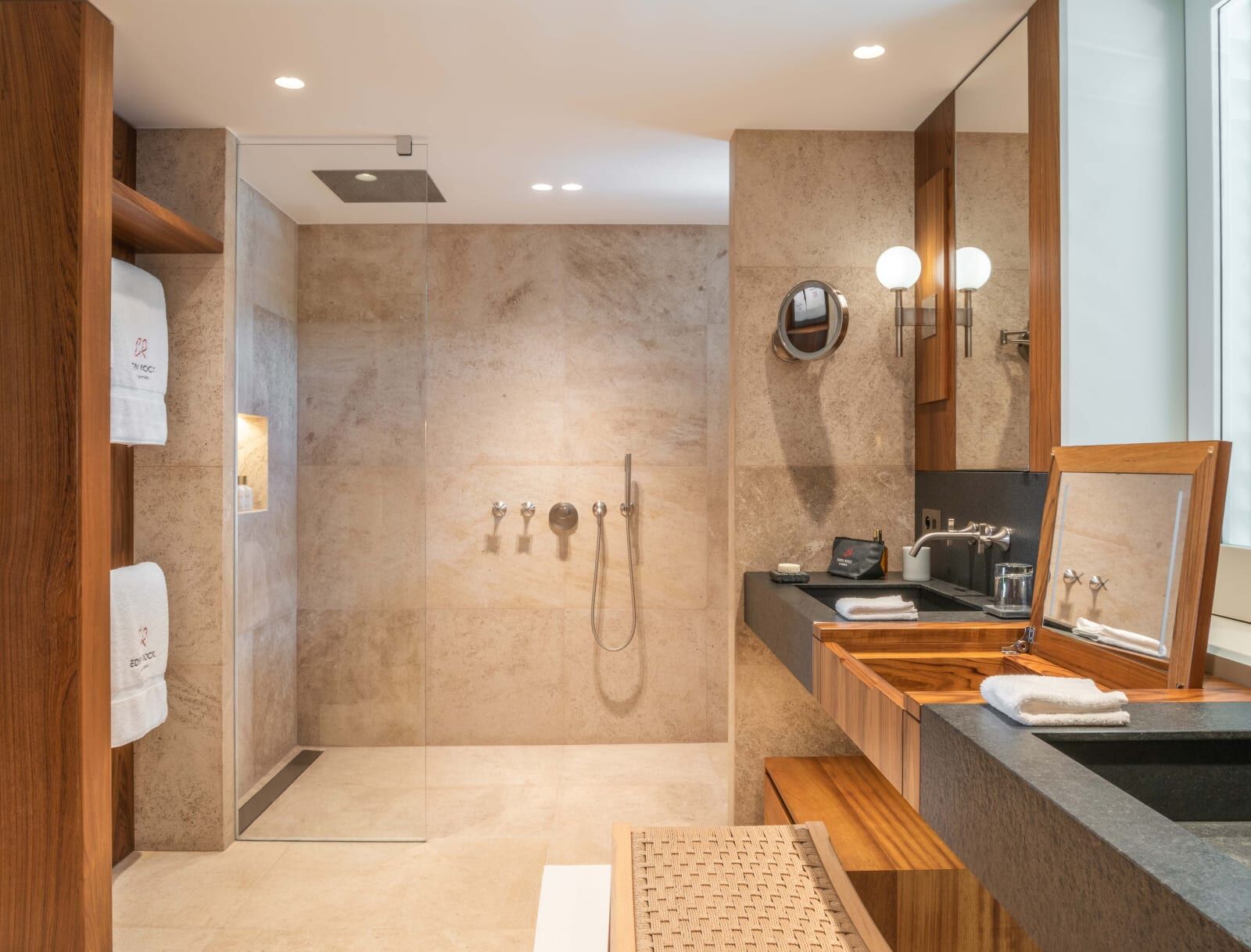 Stone walk-in shower and wooden vanity