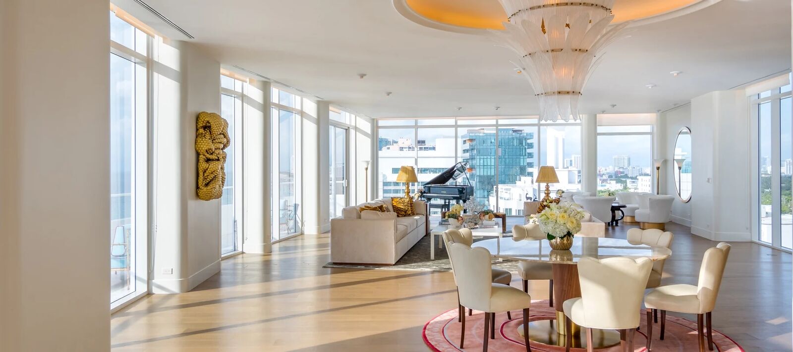 Faena Penthouse Suite living and dining room under a gold chandelier