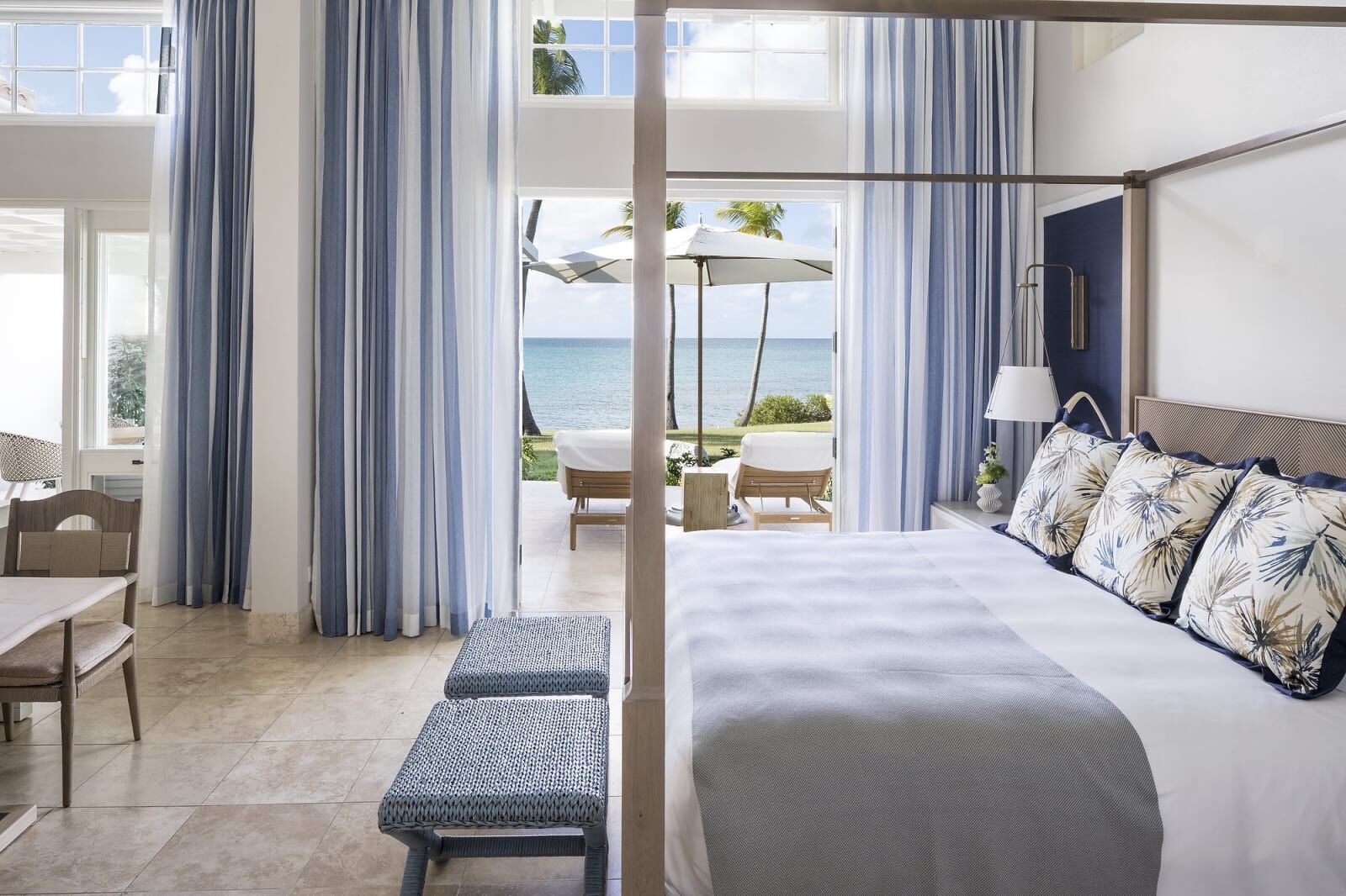 Four-poster bedroom with doors open to the sea