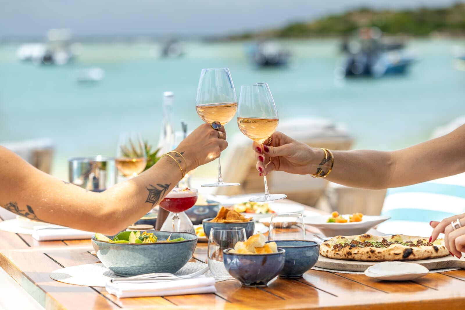 Glasses raised over lunch beside the water