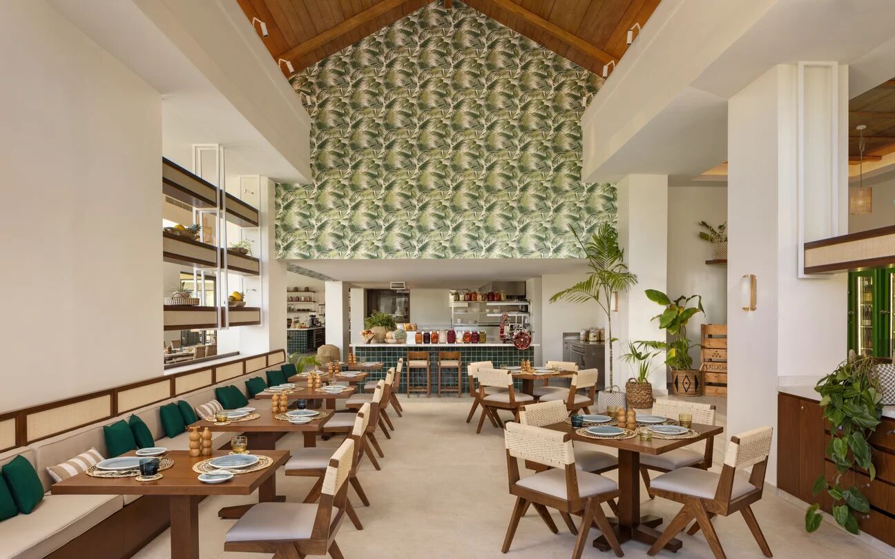 Restaurant dining room beneath a palm-print wall
